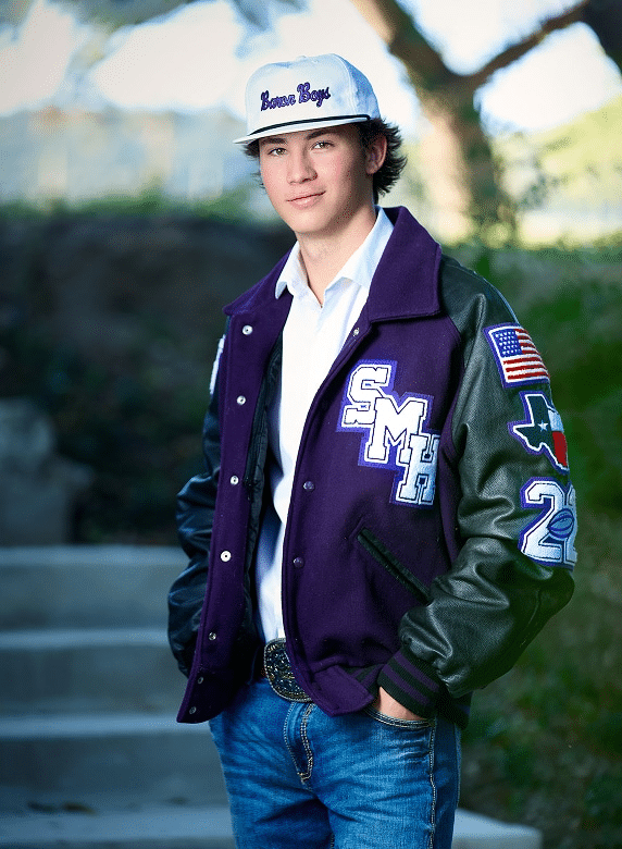 Best Tips for Creating a Memorable Senior Portrait Session 29 Young man in letterman jacket and white cap standing outdoors.