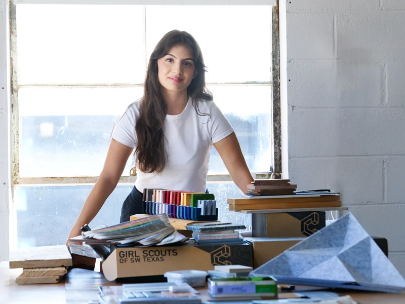 How Strong Brand Photography Helps Clients Choose You 28 Woman standing behind a table of design materials