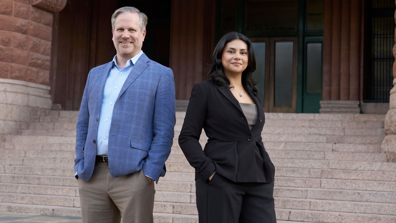 Corporate portrait of two professionals standing outside a courthouse, highlighting professional legal team photography.